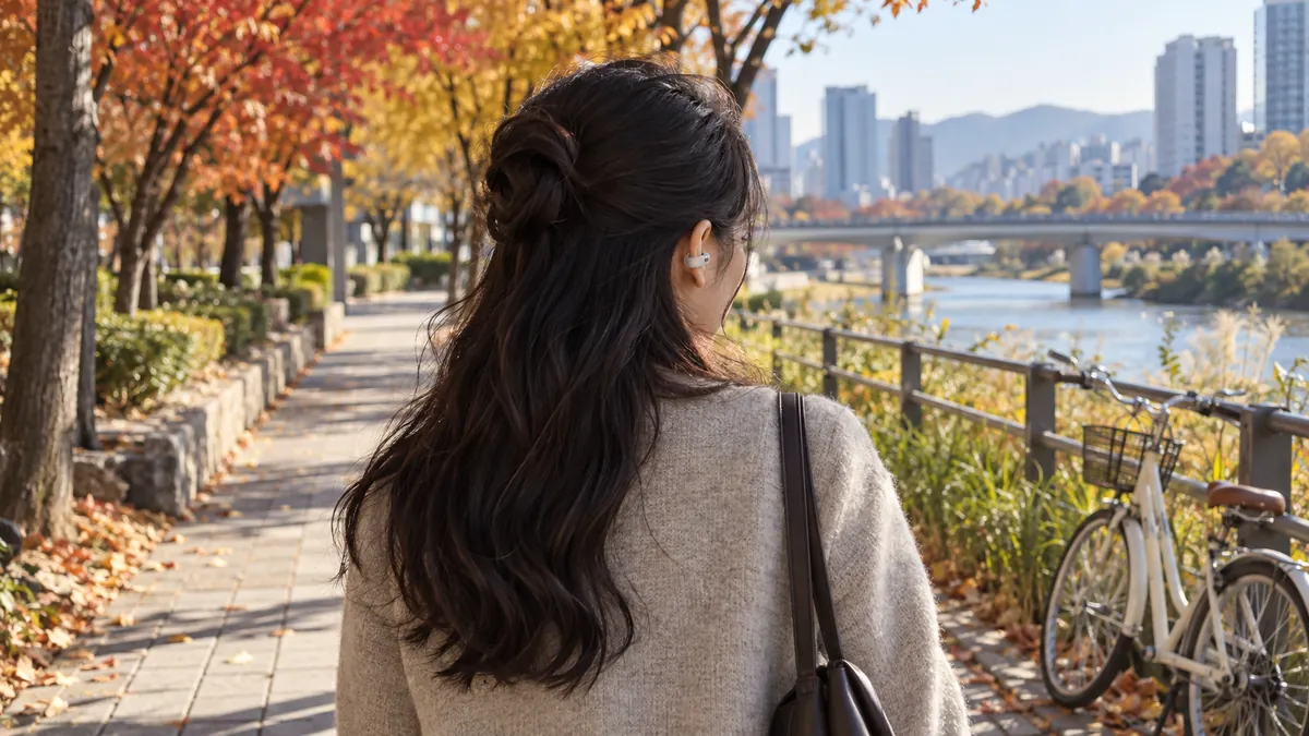 걸으며 이어폰 낀 쪽 귀 옆 도시 거리 풍경을 뒤에서 본 사람